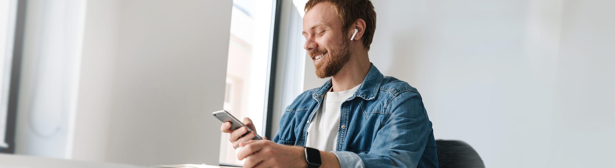 Herr bucht Coiffeur Termin online mit Handy